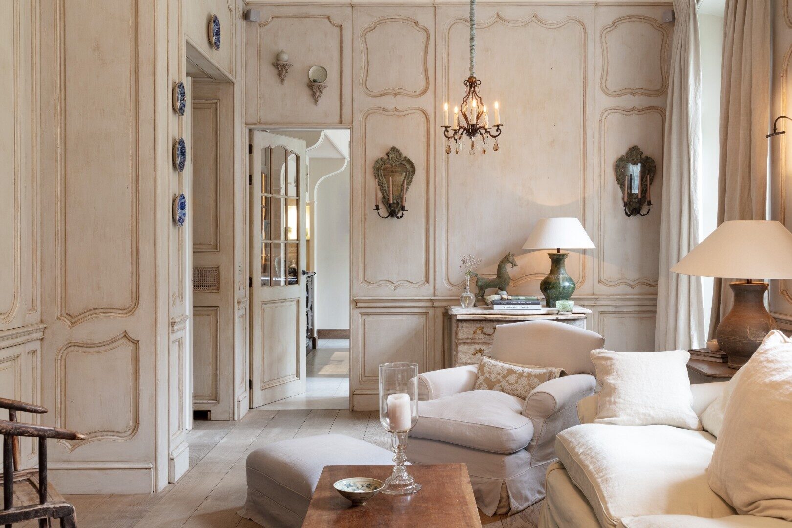 A living room wit full wall panelling. The furnitures match perfectly the panelling